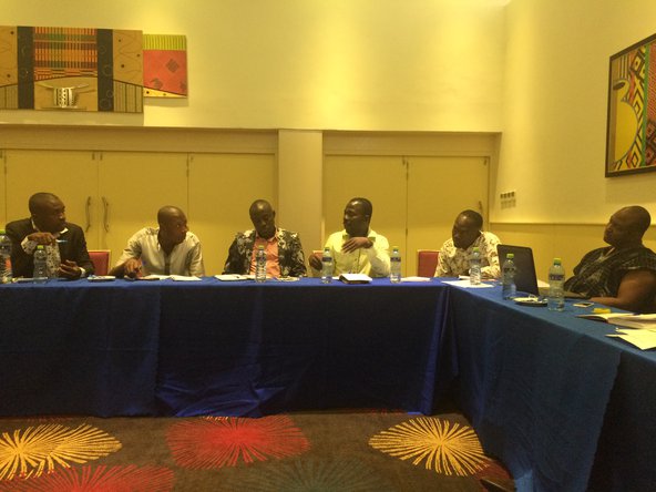 Four men sit around a table at a conference in Accra