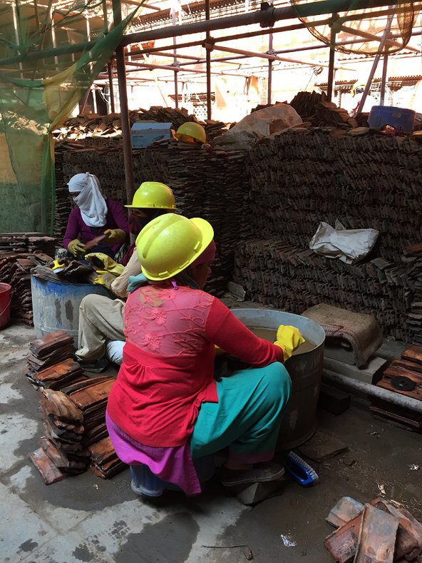 Women in hard hats work at a construction site in Kathmandu