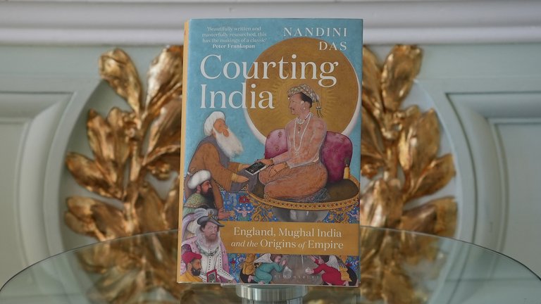 Hardback book of 'Courting India' photographed upright on a glass surface