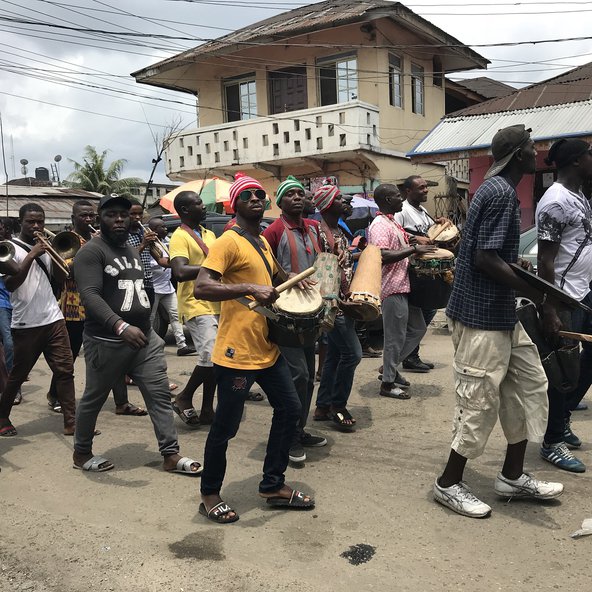 Young men in the Niger Delta in procession with musical instruments
